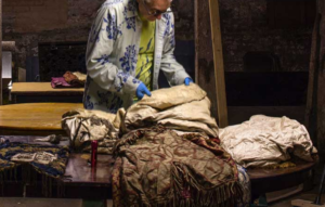 Image of a man handling Torah scroll coverings from Sandys Row