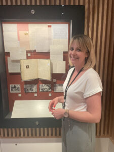 Curator Alex Cropper stands in front of a display case.