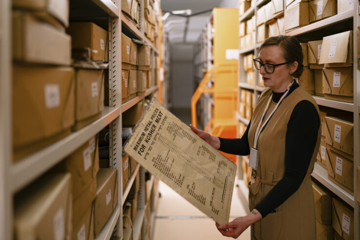 Hands wearing blue gloves turning the pages of a book