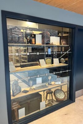 A large display of objects behind glass in a wall.