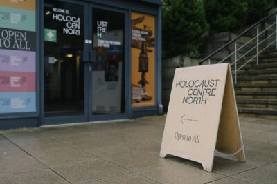A sign saying Holocaust Centre North with an arrow pointing into a building