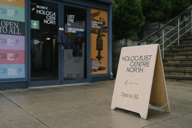A sign saying Holocaust Centre North with an arrow pointing into a building