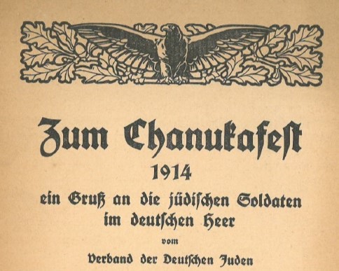 Crop of the front page of a pamphlet written in German showing an eagle design at the top above the title Zum Chanukafest.