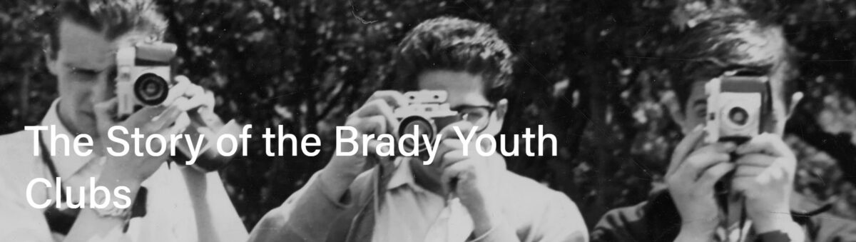 Screenshot of the website showing the title 'the story of the Brady Youth Clubs' on a black and white photo of three teenage boys with cameras. 